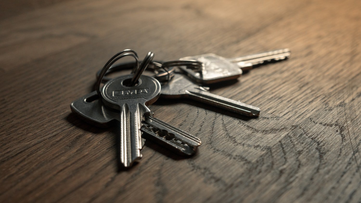 A set of keys resting on a wooden table after moving in
