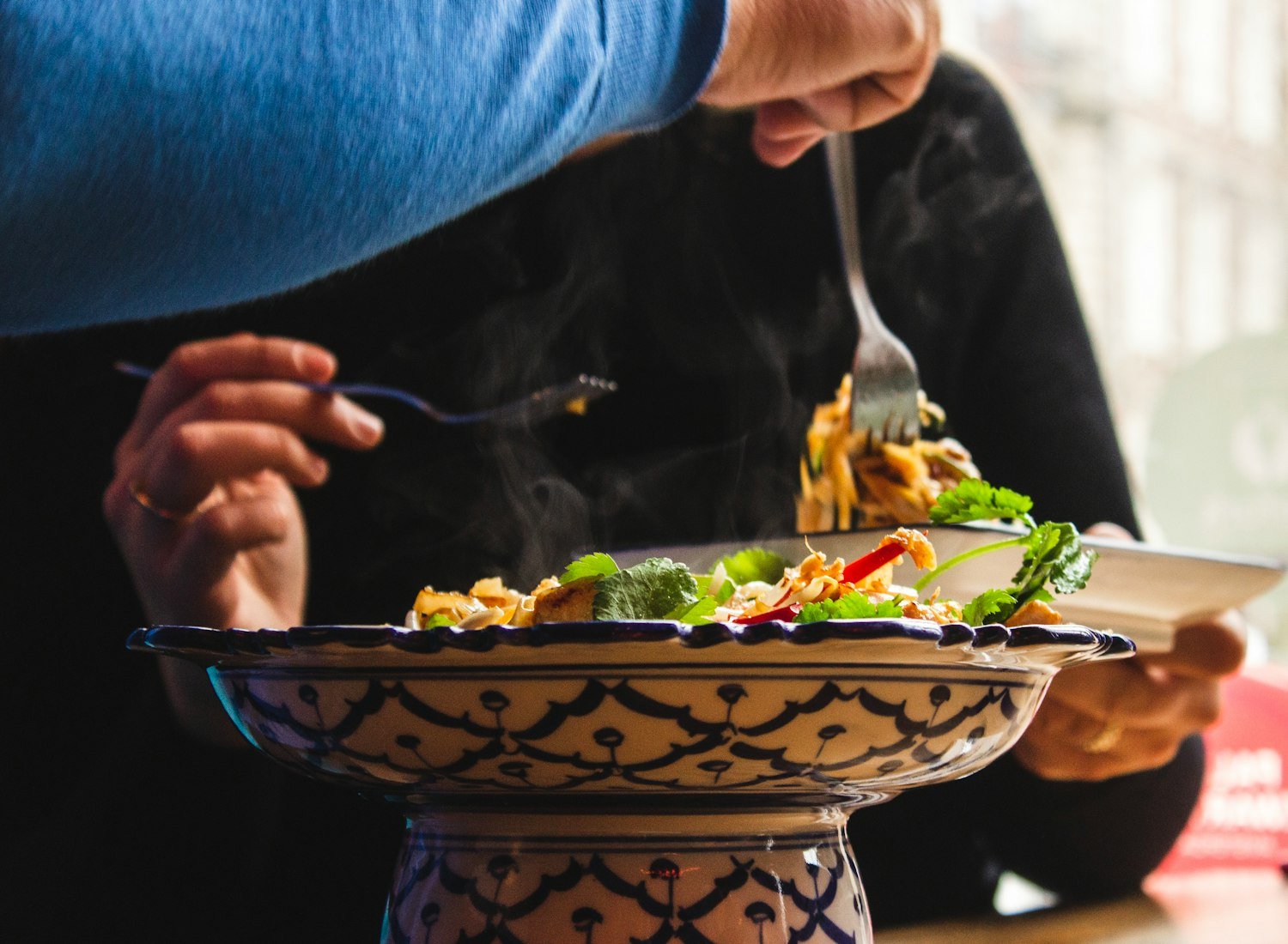 A person enjoying a cooked meal at a shared dinner table