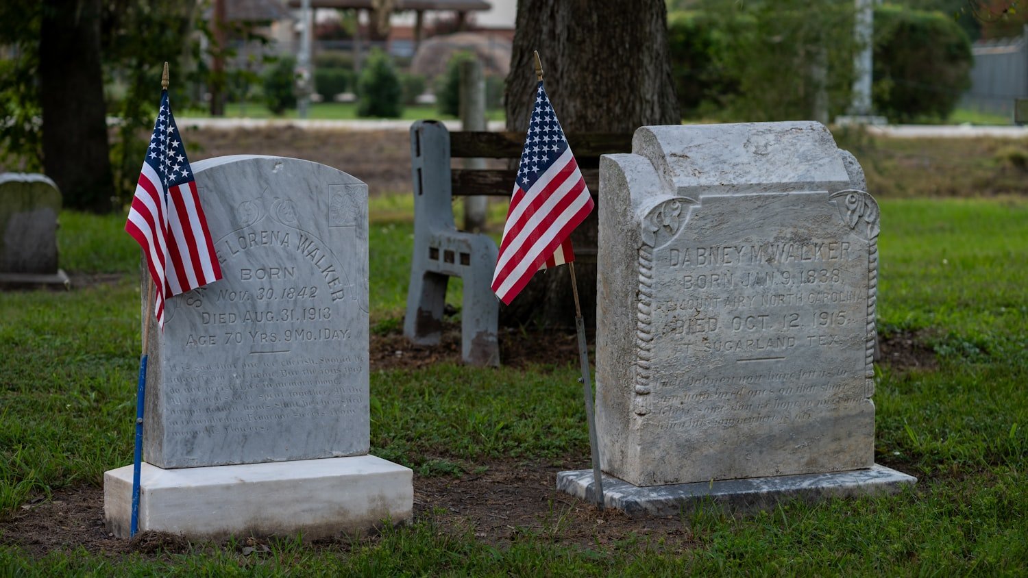 Small American flags placed in the grass, similar to those placed on veterans' graves for Memorial Day