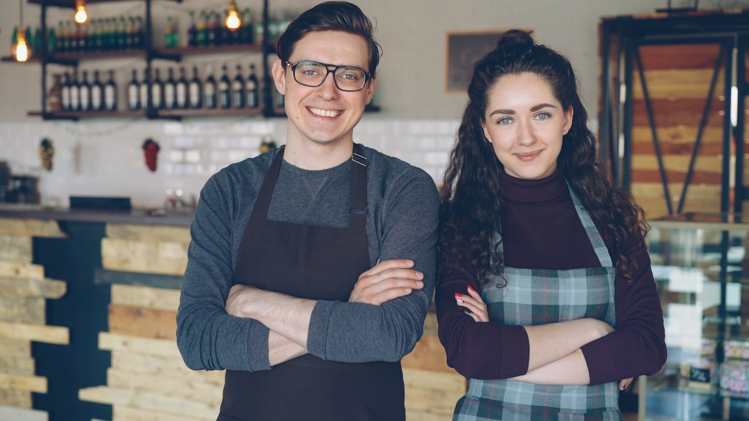 Two small business owners standing together in their shop, representing the self-employment track