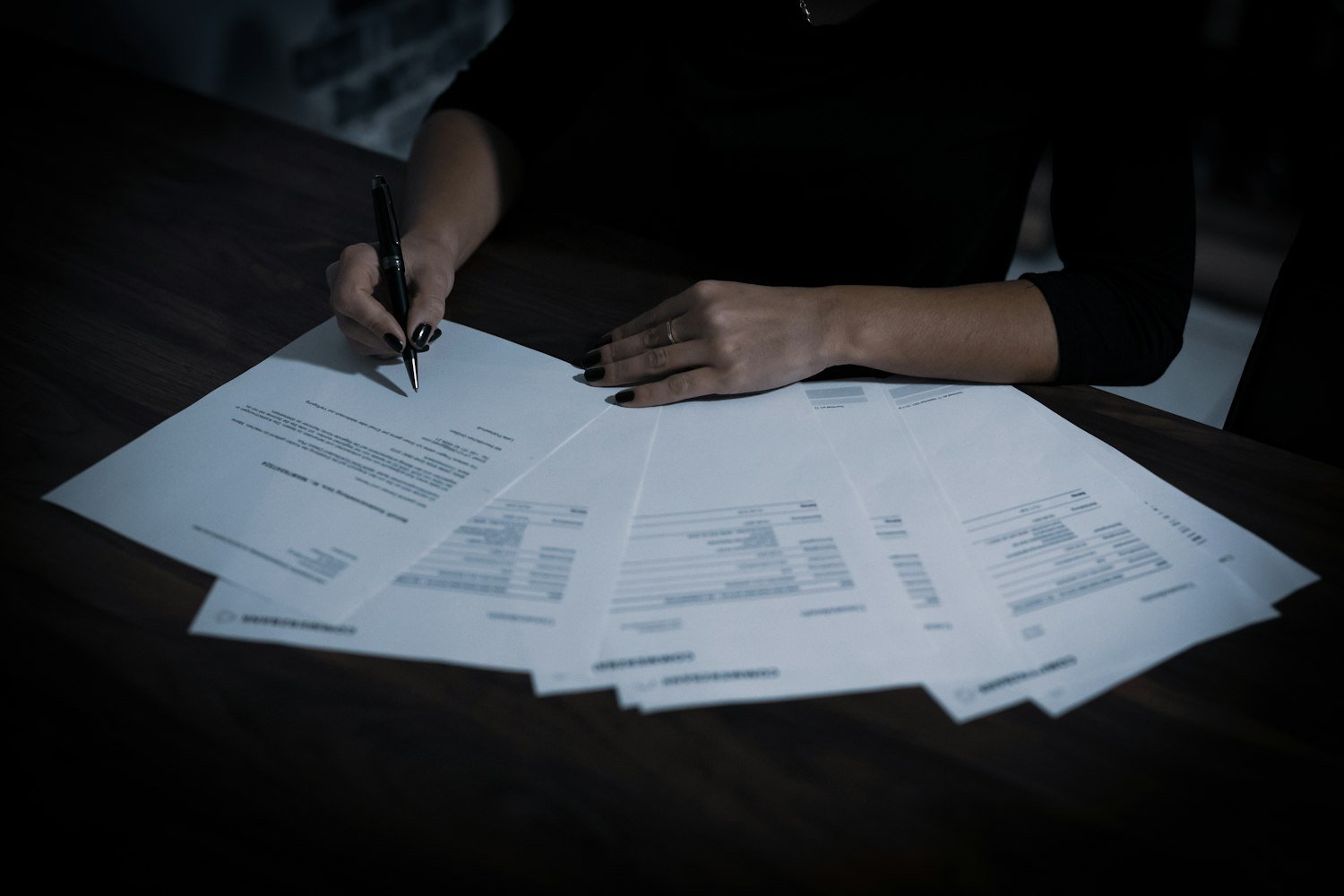 A person at a table sorting through application paperwork such as the SF-15 and DD-214