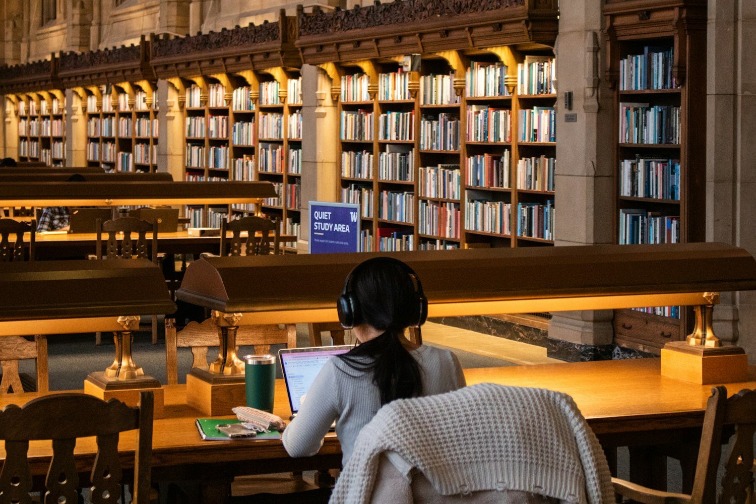A student studying with books at a library table