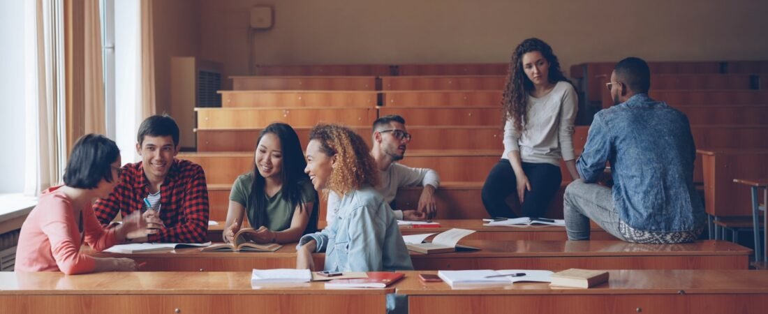 Students talking in a college lecture hall, where GI Bill education benefits are commonly used