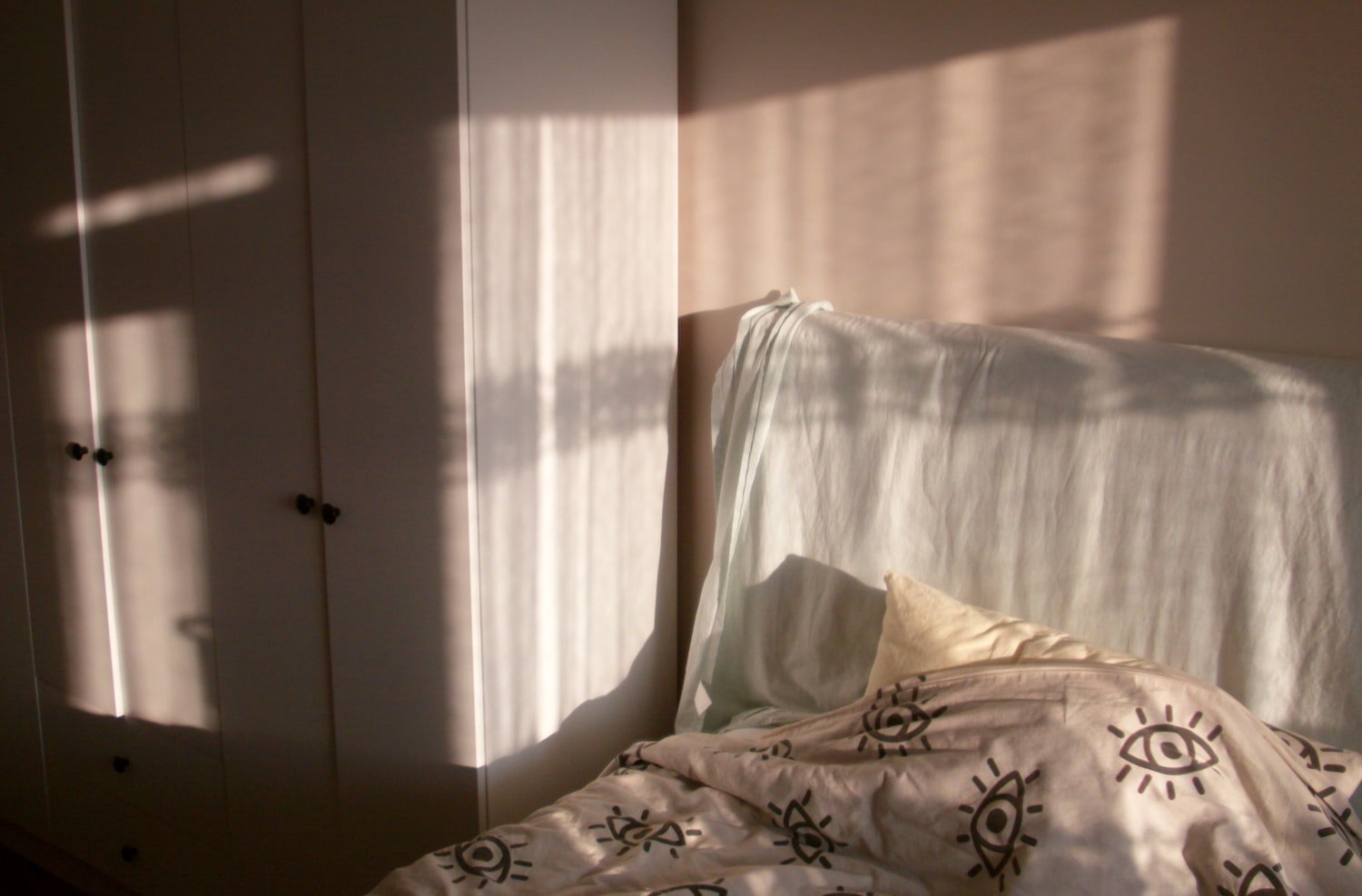 Sunlight streaming across a bed in the morning
