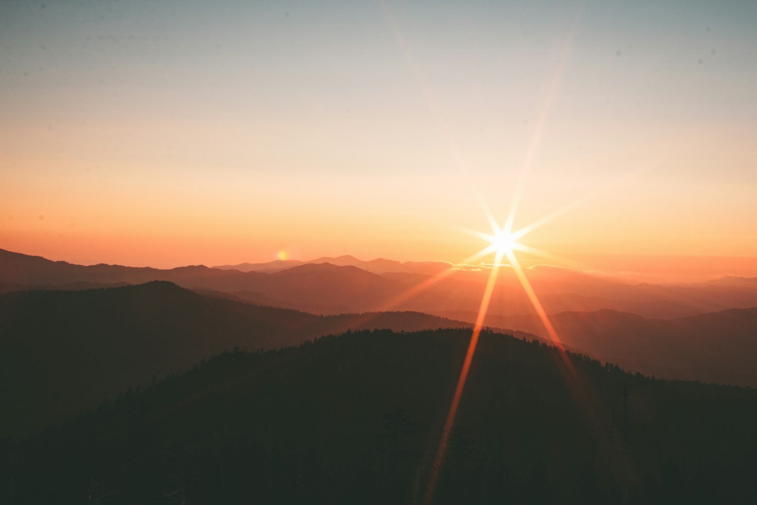 Mountains silhouetted at sunrise, representing hope and a new day