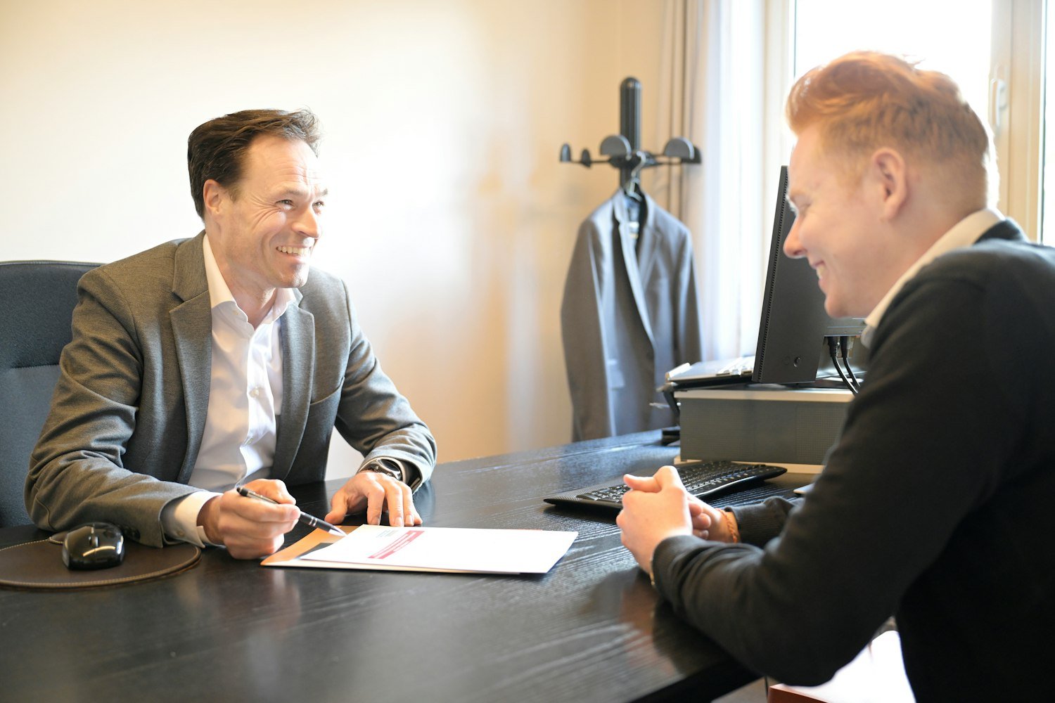 Two men reviewing documents together at an office desk