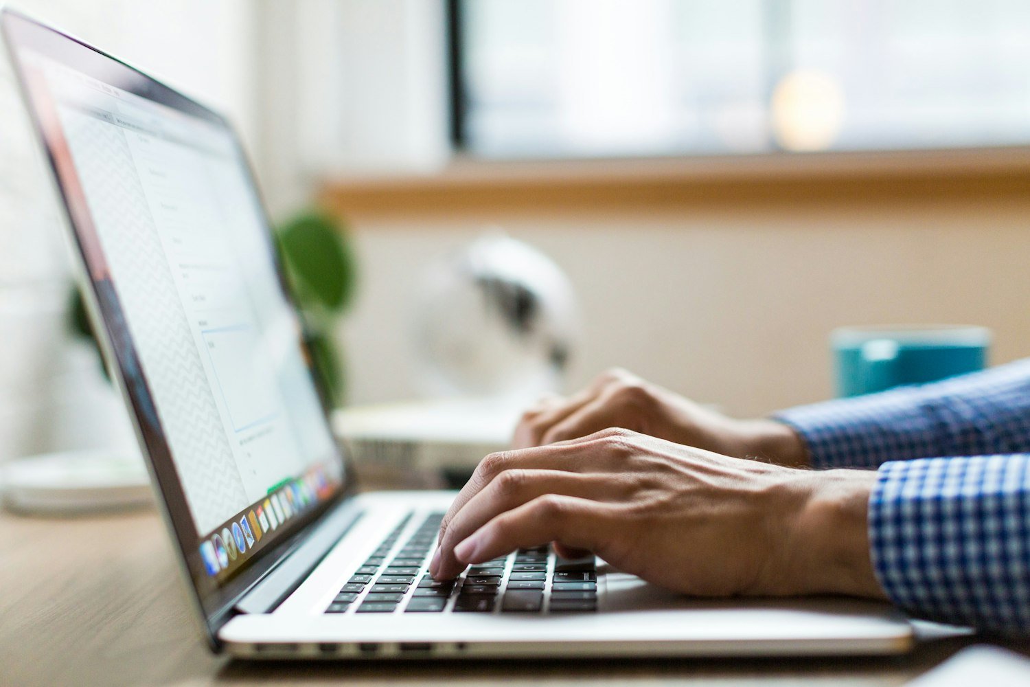 A person typing on a laptop, building the detailed federal resume applications require