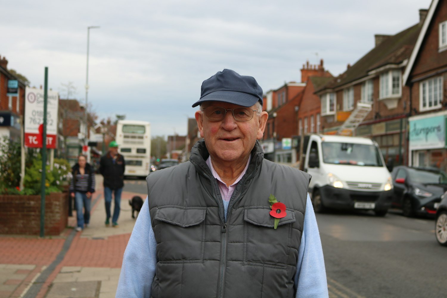 An elderly man wearing a remembrance poppy on his vest