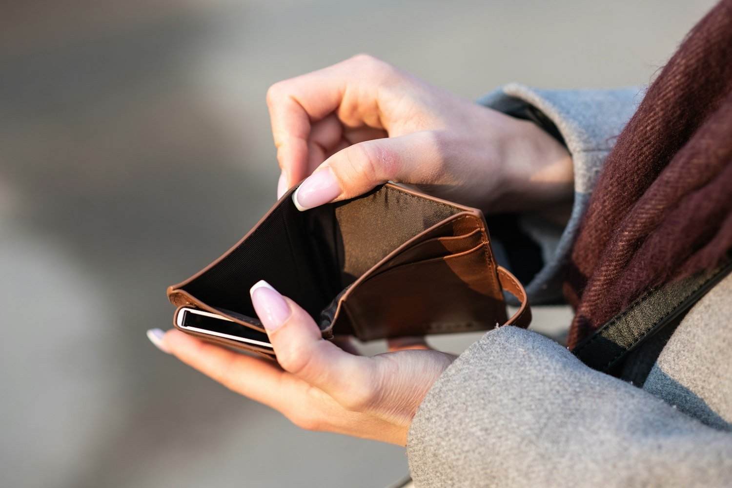 Hands holding a wallet and phone, representing physical and digital ID options