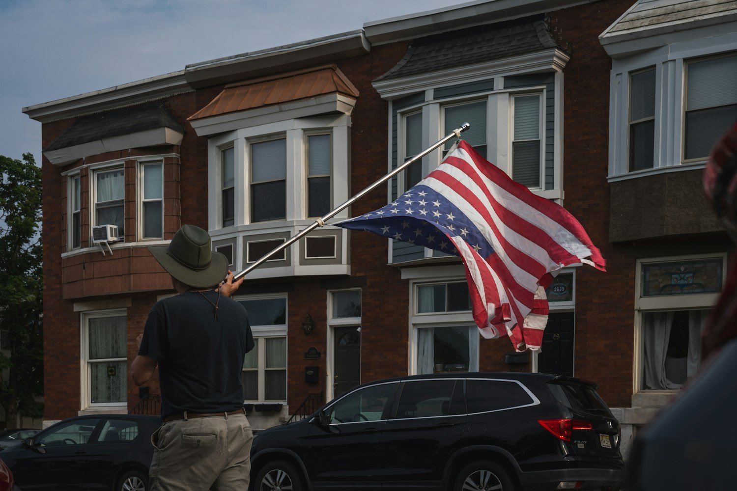 A person waving an American flag, as at a Veterans Day parade