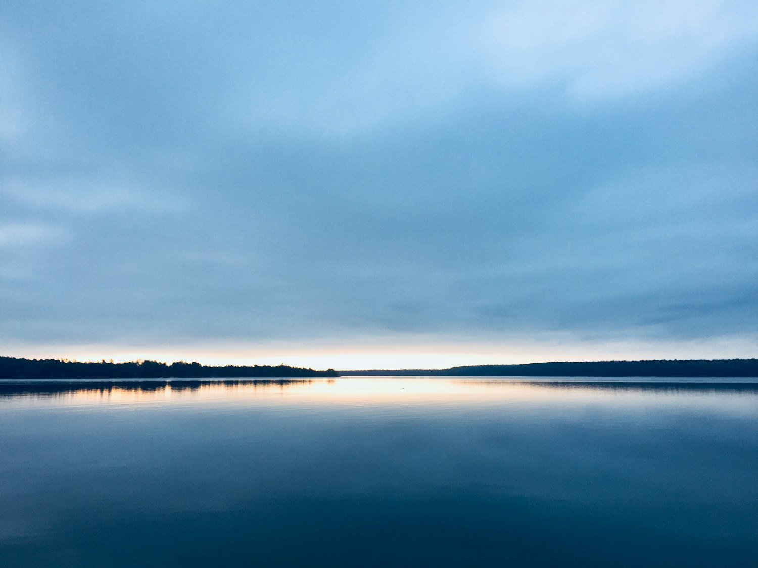A wide lake at sunset with a calm horizon