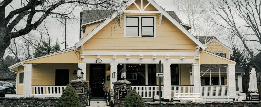 A charming yellow house with a large front porch, the kind of home a VA loan can finance