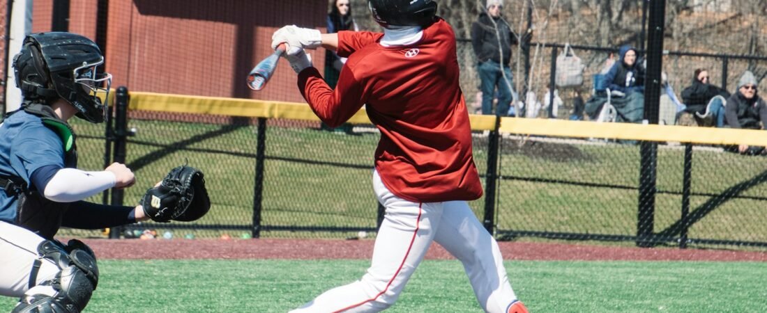 A young baseball player swinging at a pitch during a game, as in American Legion Baseball
